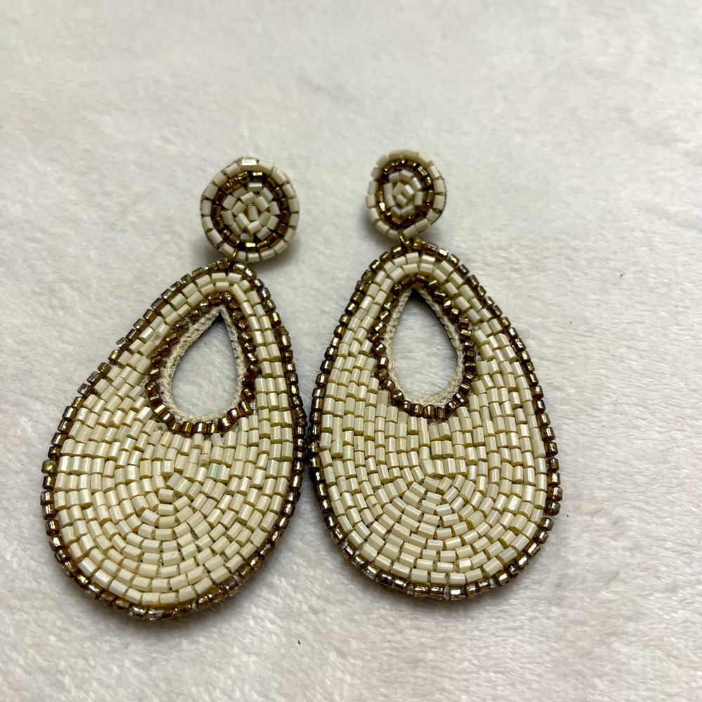 Teardrop beaded dangle earrings made entirely with white and gold beads.